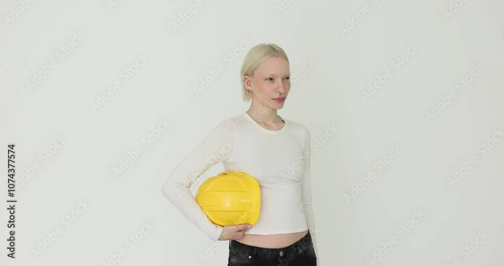 Woman holds yellow hard hat on white background Woman holds yellow hard hat on white background