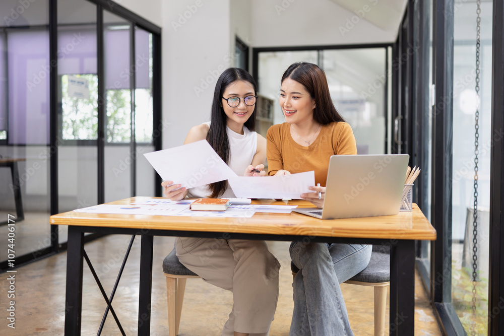 young asian businesswoman working on laptop with finances analysis report at desk in office, business financing, accounting banking,