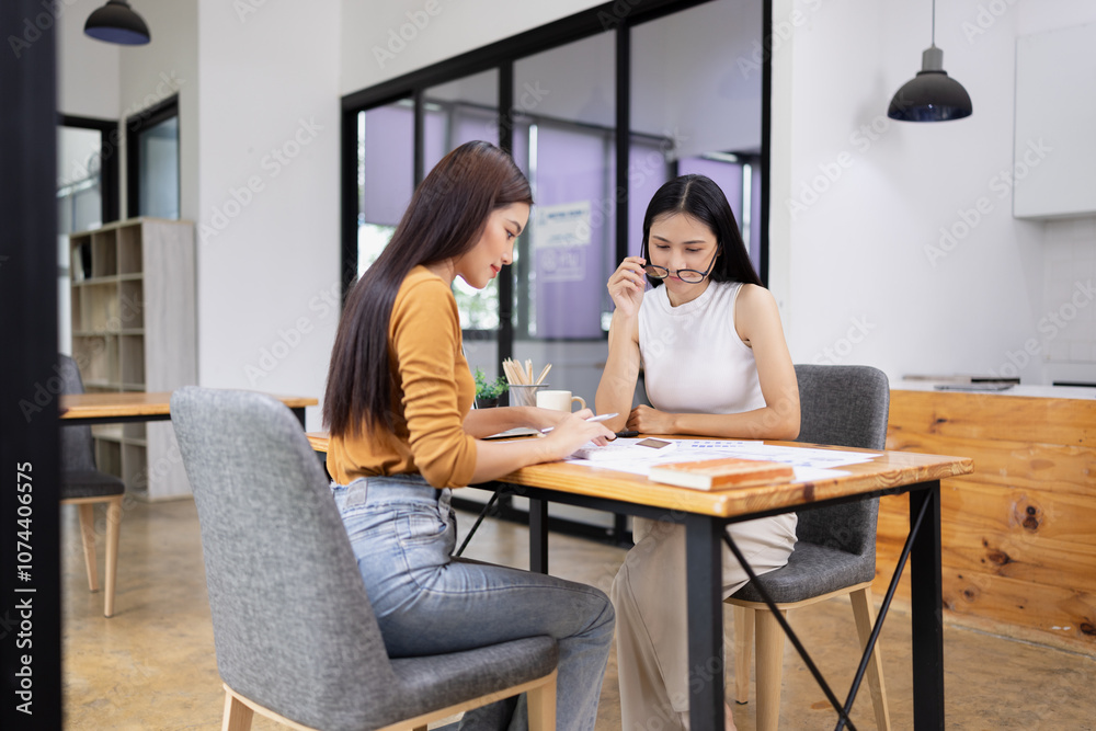 young asian businesswoman working on laptop with finances analysis report at desk in office, business financing, accounting banking, young asian businesswoman working on laptop with finances analysis report at desk in office, business financing, accounting banking,