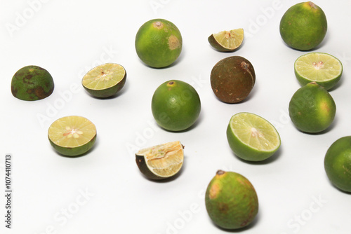 Green lime fruits on isolated white background. Sliced and unsliced. photo