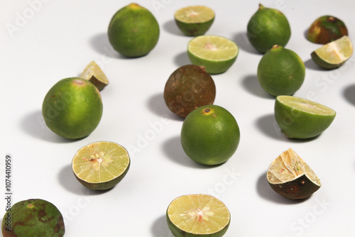 Green lime fruits on isolated white background. Sliced and unsliced. photo