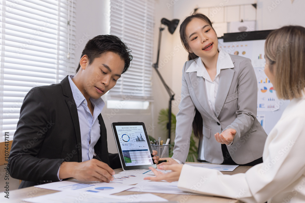 Asian business teamwork working on digital tablet with analysis report and advisor showing plan, Financial analysis and Marketing teamwork concept. Asian business teamwork working on digital tablet with analysis report and advisor showing plan, Financial analysis and Marketing teamwork concept.