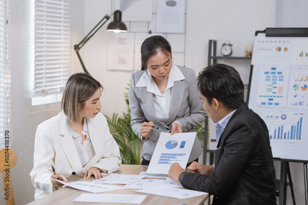 Fototapeta premium Asian business teamwork working on digital tablet with analysis report and advisor showing plan, Financial analysis and Marketing teamwork concept.