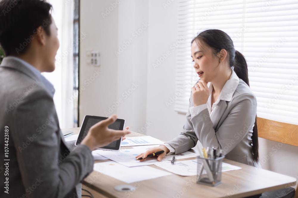 Two business people working with business financing accounting banking and laptop with finances analysis report at desk in office. Two business people working with business financing accounting banking and laptop with finances analysis report at desk in office.