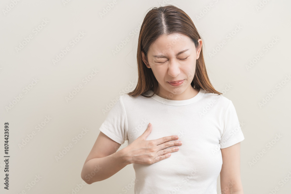 Acid reflux disease, suffer asian young woman have symptom gastroesophageal, esophageal, stomach ache and heartburn pain hand on chest from digestion problem after eat food, Healthcare medical concept Acid reflux disease, suffer asian young woman have symptom gastroesophageal, esophageal, stomach ache and heartburn pain hand on chest from digestion problem after eat food, Healthcare medical concept