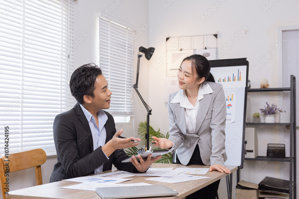 Two business people working with business financing accounting banking and laptop with finances analysis report at desk in office. Two business people working with business financing accounting banking and laptop with finances analysis report at desk in office.