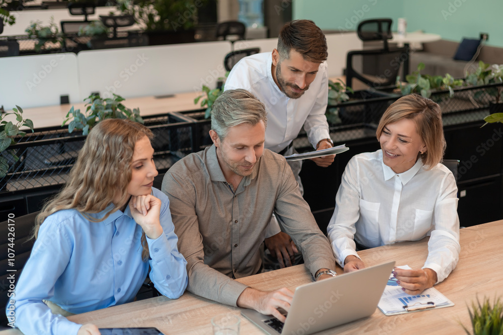 Successful businesspeople working in a coworking space working with laptop discussing strategy and business plan in modern office. Successful businesspeople working in a coworking space working with laptop discussing strategy and business plan in modern office.
