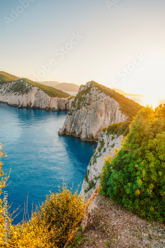 Lighthouse on the cliff. Seascape of Cape Lefkatas with old lighthouse on Lefkada island, Greece. Beautiful views of azure sea water and nature with cliffs photo