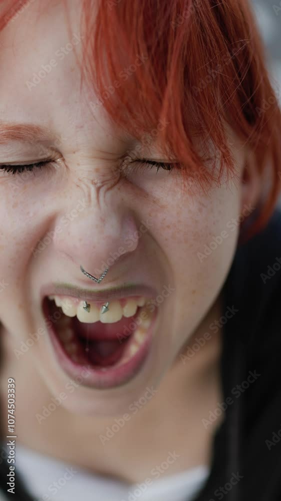 vertical shot. Young girl angry and screaming. Upset girl screaming, teenager with facial piercing. shock and emotional breakdown, depression. vertical shot. Young girl angry and screaming. Upset girl screaming, teenager with facial piercing. shock and emotional breakdown, depression.