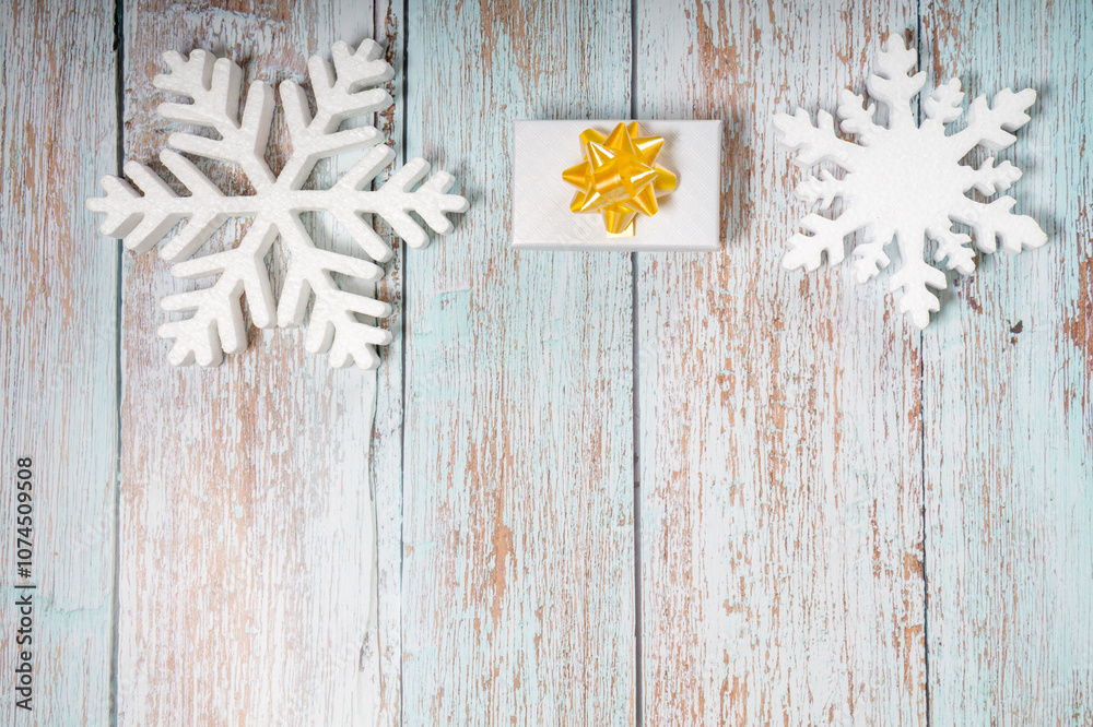 White decorative snowflakes and giftbox on white wooden background, copy space White decorative snowflakes and giftbox on white wooden background, copy space