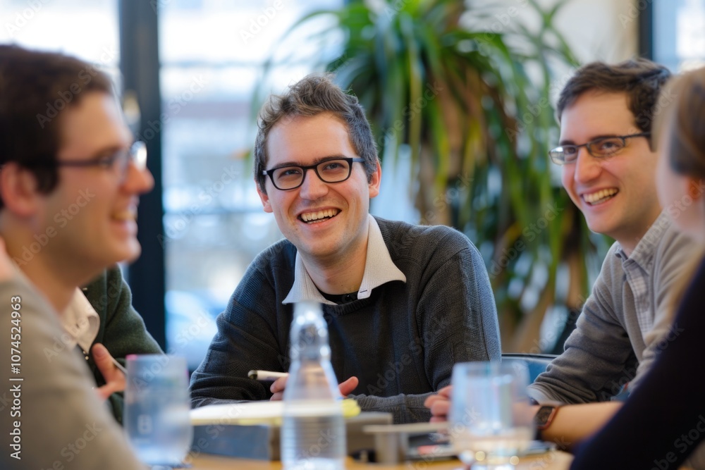A group of people sitting around a table, possibly discussing or working together A group of people sitting around a table, possibly discussing or working together