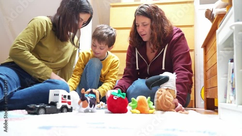 LGBT family of two lesbian mothers with their son playing at home