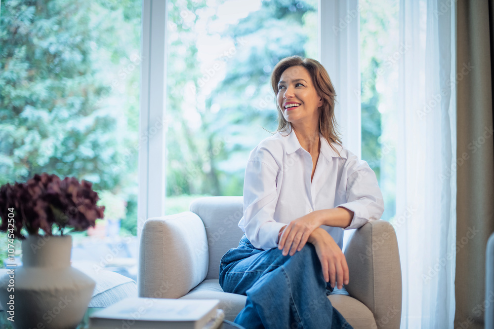 Portrait of an attractive woman relaxing in an armcha by the window Portrait of an attractive woman relaxing in an armcha by the window