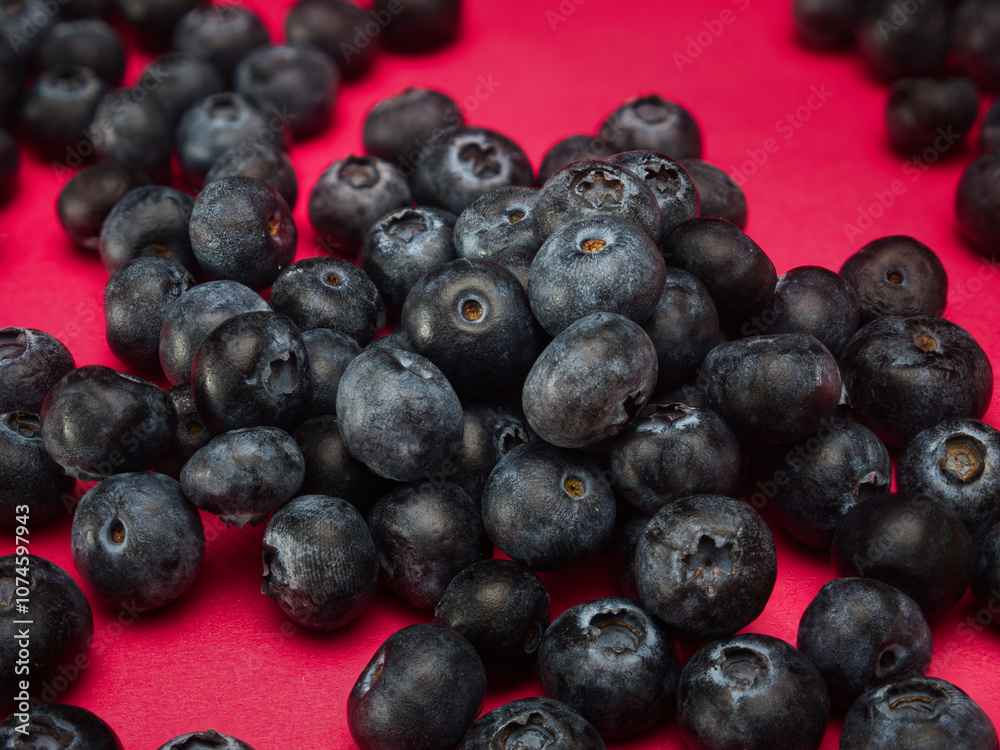 A pile of blueberries isolated on red background A pile of blueberries isolated on red background