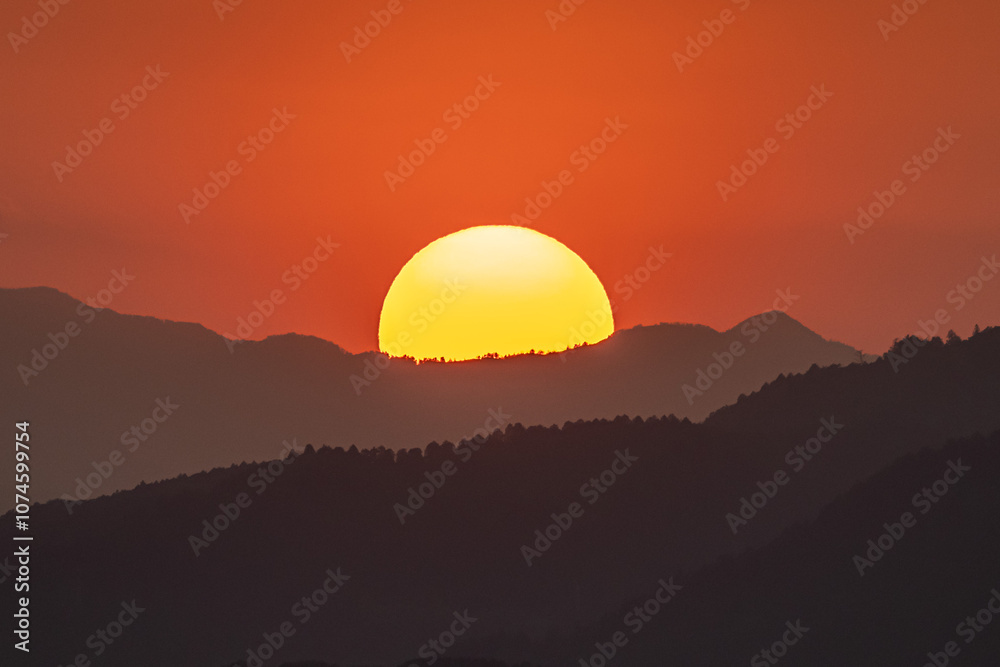 夕焼けの中、山に沈む太陽 夕焼けの中、山に沈む太陽