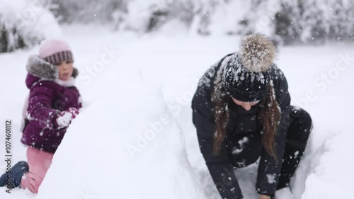 Mother and daughter enjoy a snowy day together, creating memories and sharing winter joy in a beautiful landscape