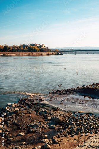 Petrovaradin fortress over Danube river with sewage outflow photo