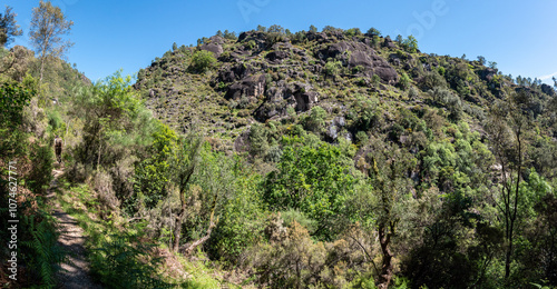 A woman hiking alone to the Rajada waterfall in Peneda Geres National Park in Portugal