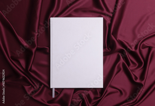 Top down view of empty book template on maroon silk.