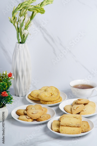 Mix variety of different cookies on the white background with a cup of tea photo