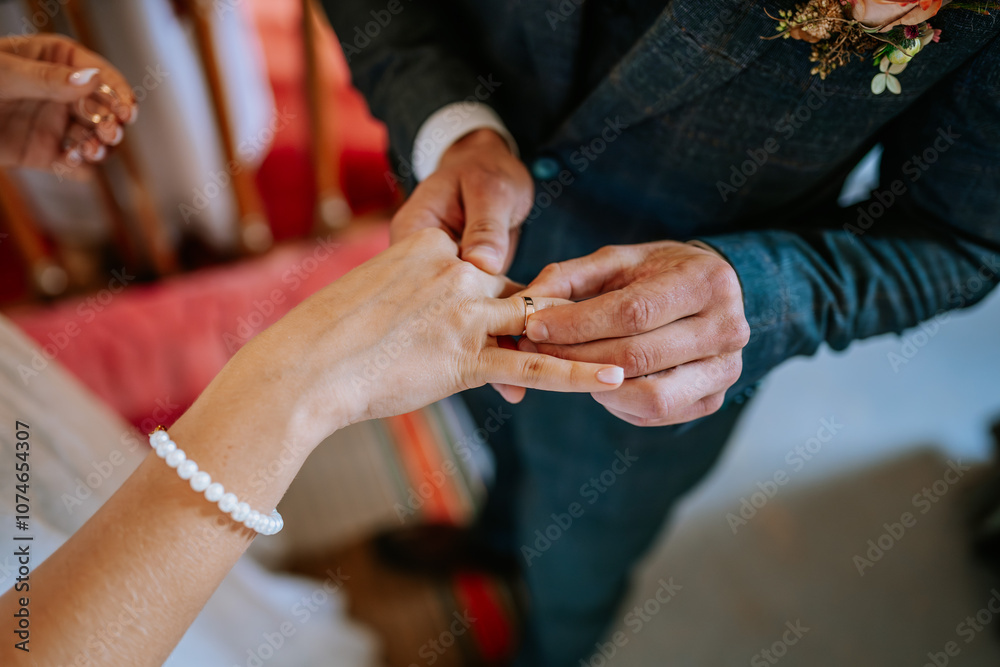 Close-up of a groom placing a wedding ring on the bride’s finger during a ceremony, symbolizing their commitment and love.. Close-up of a groom placing a wedding ring on the bride’s finger during a ceremony, symbolizing their commitment and love..