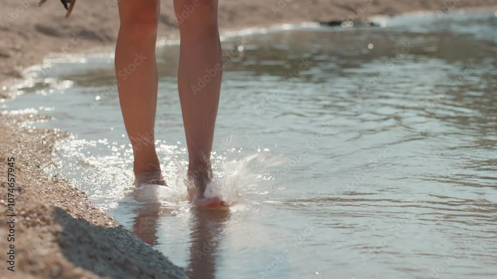 Female tourist walking barefoot on seashore enjoying summer vacation, refreshing her feet in water. Close up of woman walks along pebble beach Female tourist walking barefoot on seashore enjoying summer vacation, refreshing her feet in water. Close up of woman walks along pebble beach