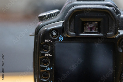 Dusty DSLR Digital single-lens reflex camera with menu, jump and playback button. view finder and lcd screen. Old photography gear.
