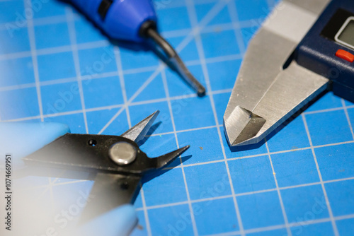Imperial/Metric Vernier Caliper,  Flush Cutters Side snippers, and deburring tool on a blue cutting mat for hobby use and design