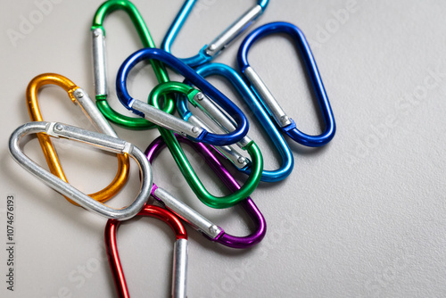 Colourful collection of  D-Ring Locking colour carabiners loosely piled up on a desk.