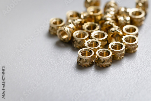 Close up of a pile of M4 metric brass inserts for 3d prints. and injection molded parts.