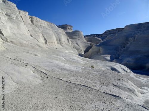 lunar landscape valley in sarakiniko, milos island, greece. Cyclades island with white stones of pumice forming a canyon in sunlight.  Moon like travel destination and desertic area photo