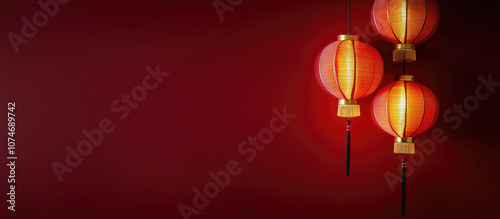 Modern wicker pendant lamps with warm light against red background in minimalist interior