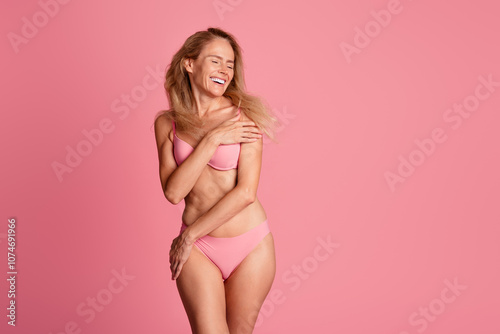 Photo of adorable cheerful woman wear stylish underwear hug slender healthy body isolated on pink color background