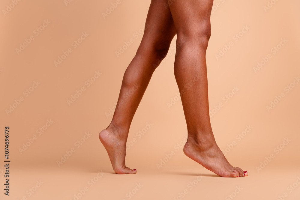 Cropped studio no retouch photo of fit lady legs walking empty space isolated ivory color background Cropped studio no retouch photo of fit lady legs walking empty space isolated ivory color background