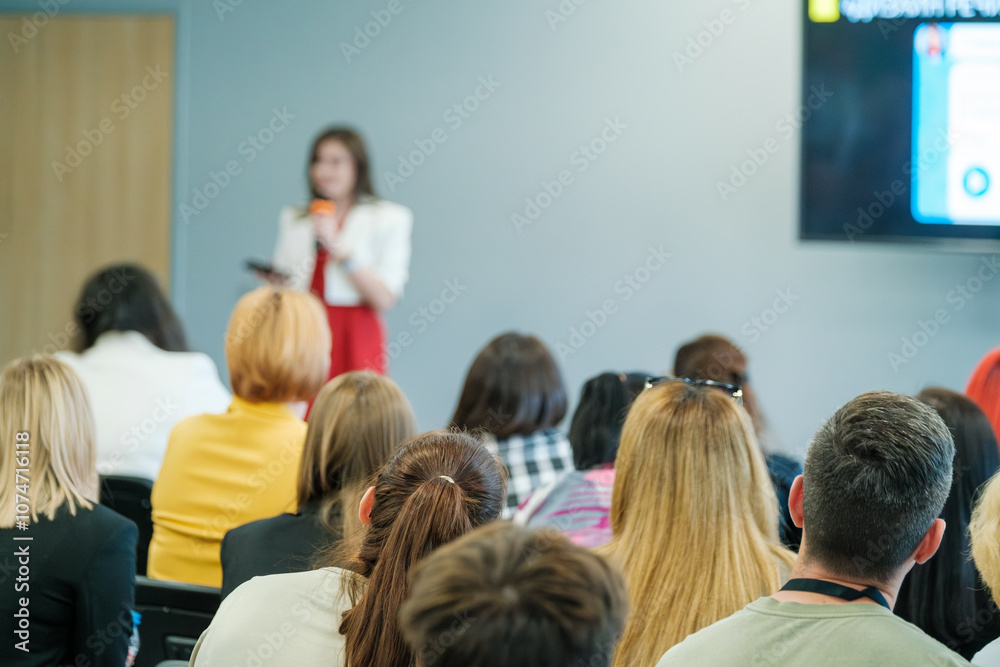 Fototapeta premium Business meeting seminar with attentive audience listening to a speaker. Professional presentation discussing important topics in a conference room.