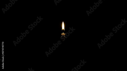 A lighted match burns against a black background, illuminating the surrounding darkness.