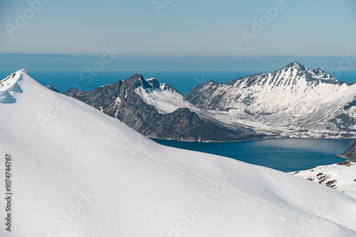 Side view of a snow-covered mountain slope with traces of the skis of skiers