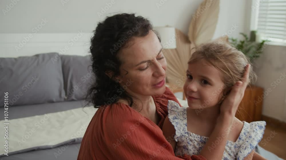 Medium close up of Caucasian single mother hugging her daughter while resting at home Medium close up of Caucasian single mother hugging her daughter while resting at home