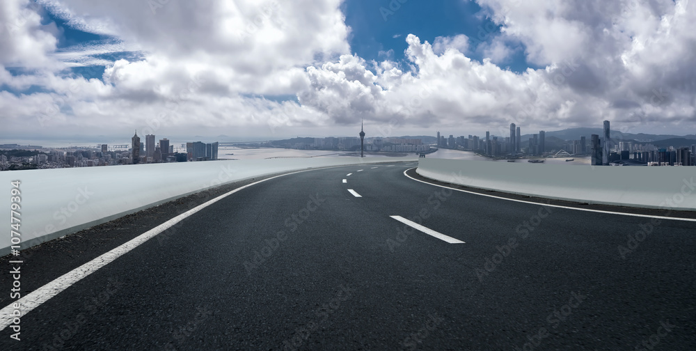 Fototapeta premium Scenic Urban Roadway Leading to a Vibrant City Skyline Under Dramatic Clouds