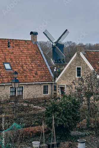 View between Dutch house roofs on the windmill of the fortified town Bourtange during Christmas market.