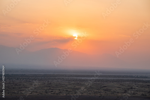 The vibrant sun is slowly setting over a vast desert landscape, Kashan, Iran