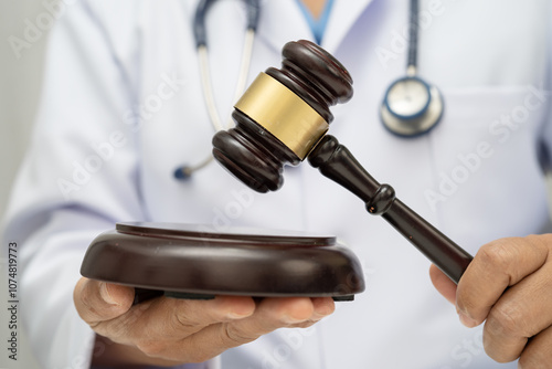 Doctor holding judge gavel, forensic medicine, medical law and crime justice concept. photo