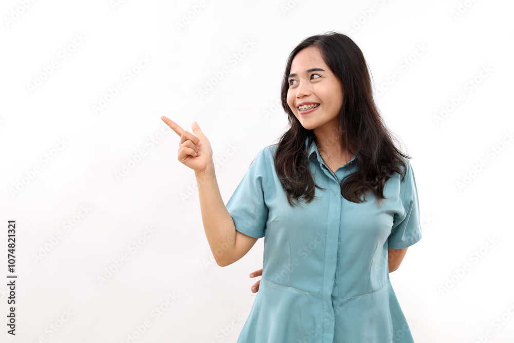 Happy Asian girl indicates at empty space for sale logo smiles positively shows something pleasant grins at camera dressed in casual shirt. Look at this promo deal. Check out this good offer Happy Asian girl indicates at empty space for sale logo smiles positively shows something pleasant grins at camera dressed in casual shirt. Look at this promo deal. Check out this good offer