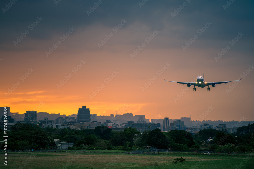 Obraz premium Airplane landing at sunset at Songshan International Airport in Taipei