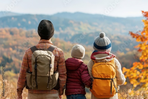 A family enjoys nature, standing together in the autumn landscape, overlooking colorful mountains and valleys.