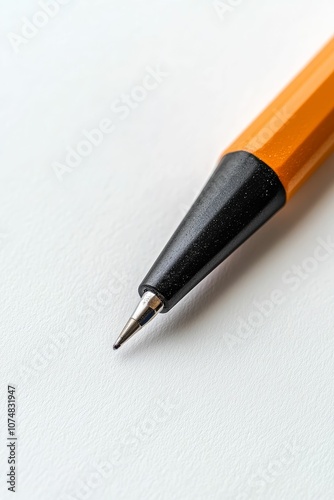 Orange pencil tip close-up on white paper.