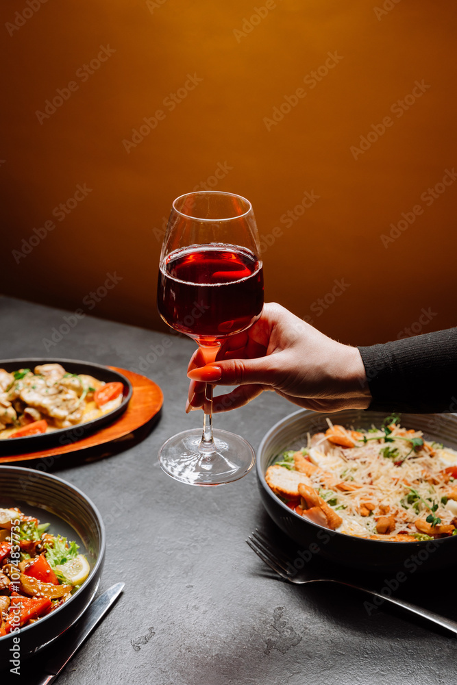 Elegant moment with glass of red wine in hand, capturing the essence of relaxing dining experience Elegant moment with glass of red wine in hand, capturing the essence of relaxing dining experience
