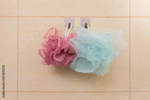 A Variety of Colorful Shower Loofahs Tastefully Hanging on the Bathroom Wall for a Splash of Fun