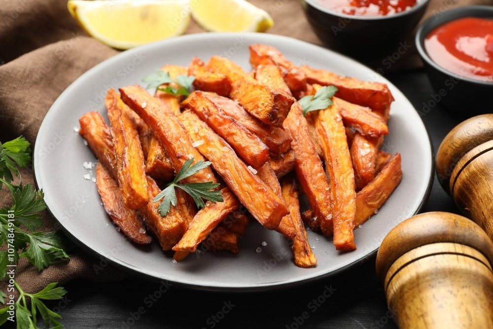 Delicious sweet potato fries with spices and sauces on table, closeup Delicious sweet potato fries with spices and sauces on table, closeup