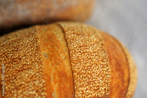 Closeup photo of crust with sesame seeds of home baked bread